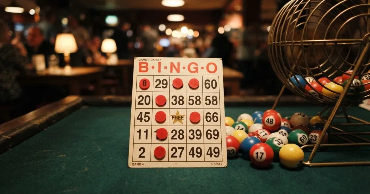 Karta do bingo z odznaczonymi liczbami obok wylosowanych kulek na stole w kasynie online